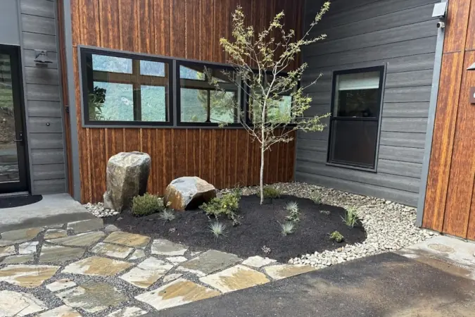 Cabin entry courtyard set with flagstone and boulders