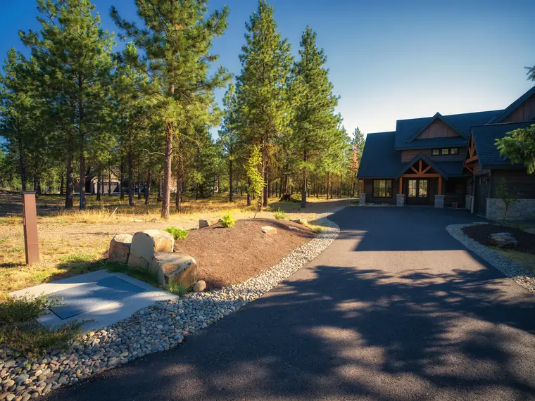 Planted boulder mound at the driveway entrance of a timber home