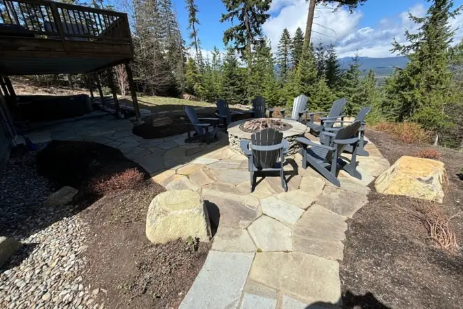 Flagstone fire-pit patio with Adirondack chairs and a mountain view