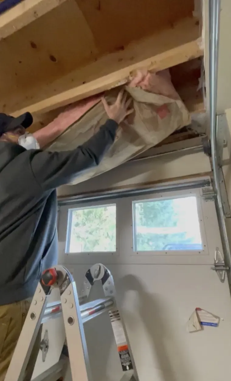 Fitting insulation into the wall above a garage door
