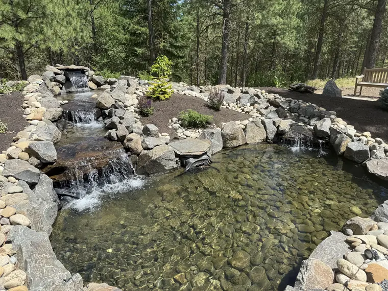 Close-up of water spilling over the stacked-stone falls into the pond
