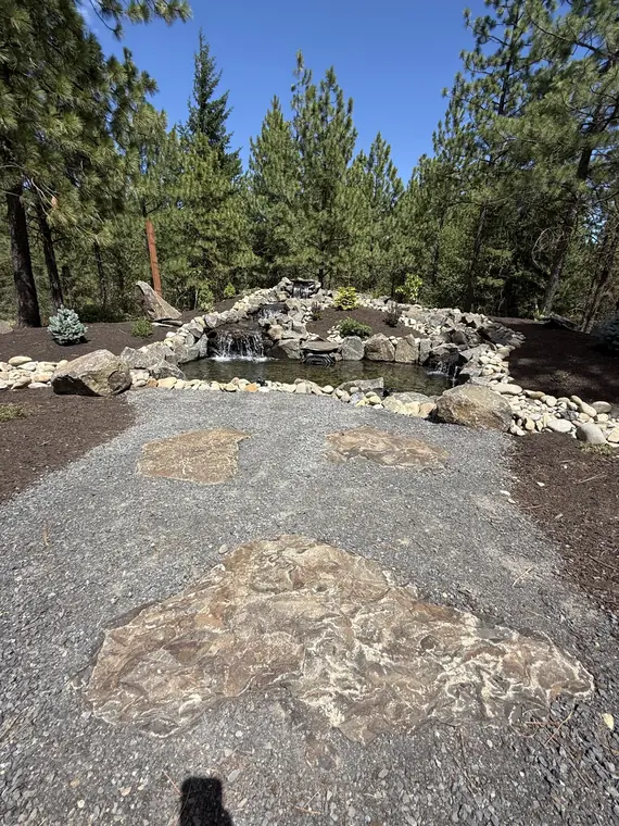 Stone path leading down to a pond and waterfall