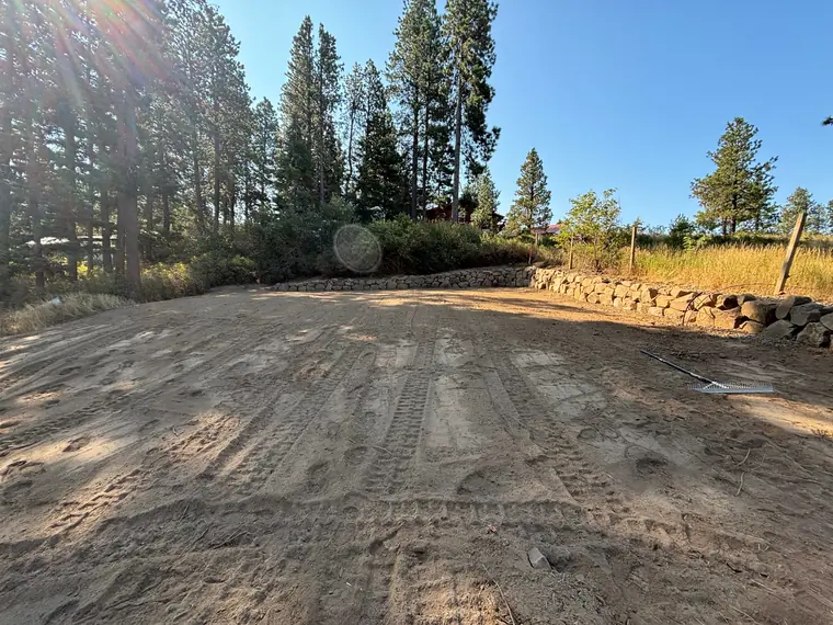 Boulder rockery along the back edge of a newly leveled yard