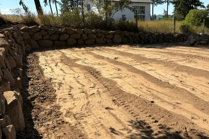 Boulder wall holding the slope beside a graded yard