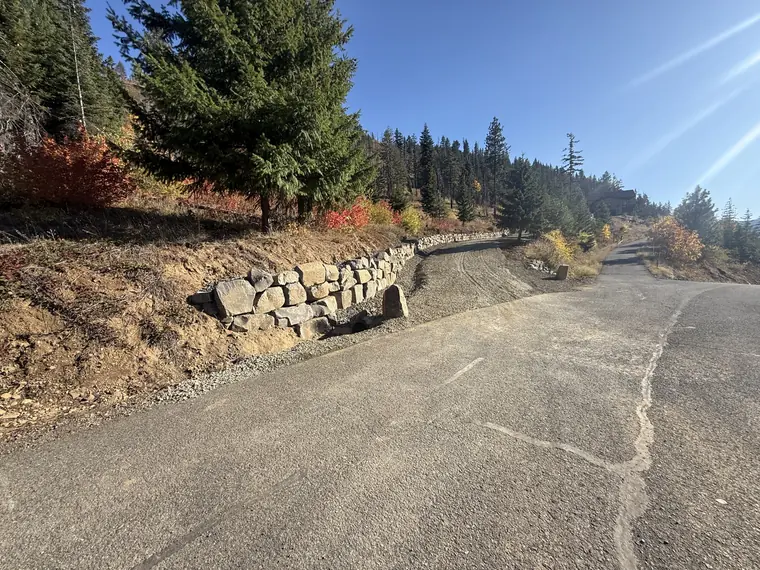 Rockery wall holding the hillside where the driveway meets the road