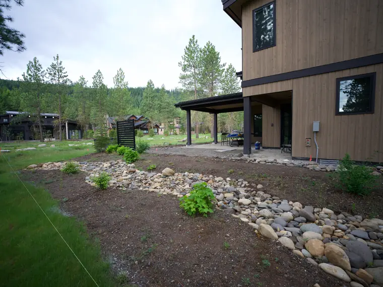During the build: river rock and new plantings along the back patio