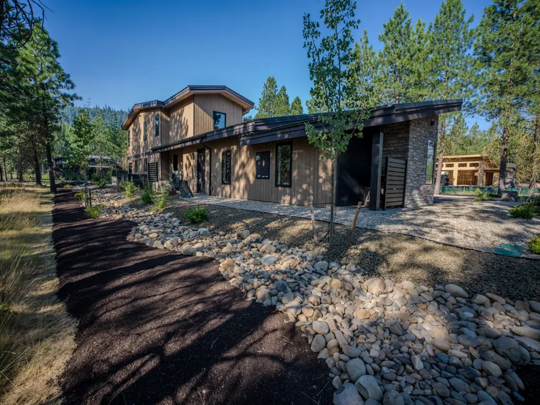 River-rock dry creek running along the side of a new home