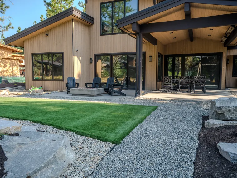 Artificial turf, a gravel path and boulders off the back patio of a Tumble Creek home